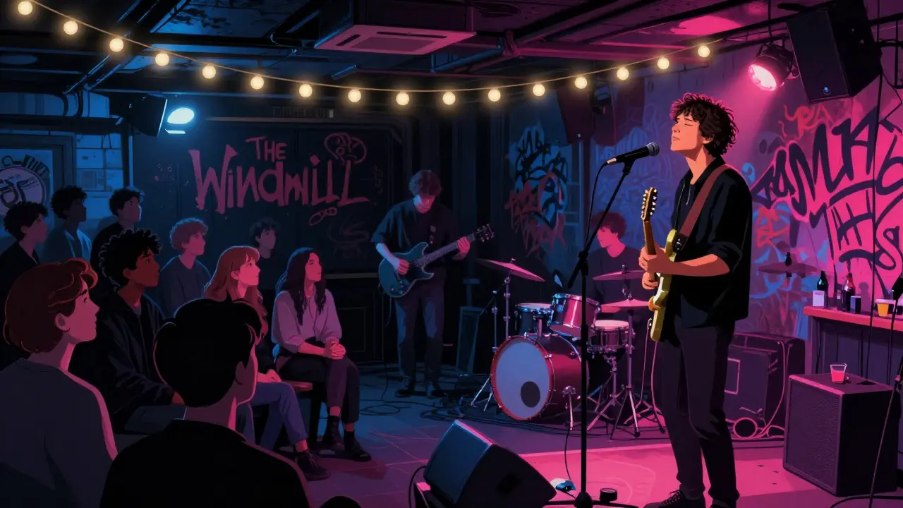 A person listens intently to a live indie band in a dim, graffiti-covered basement venue.